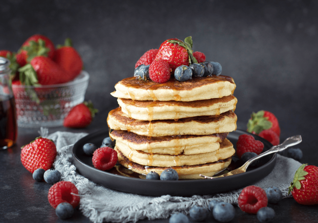 Glutenfria amerikanska pannkakor med fiberhusk. Toppade med jordgubbar, hallon, blåbär och maple syrup